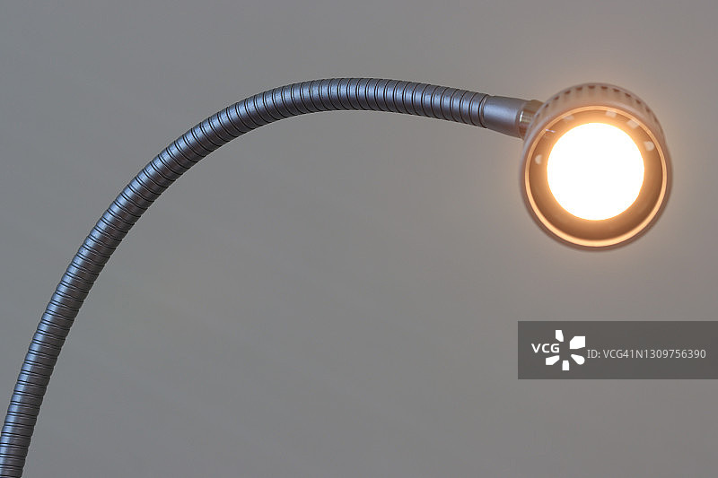 金属鹅颈台灯特写，灯光明亮图片素材
