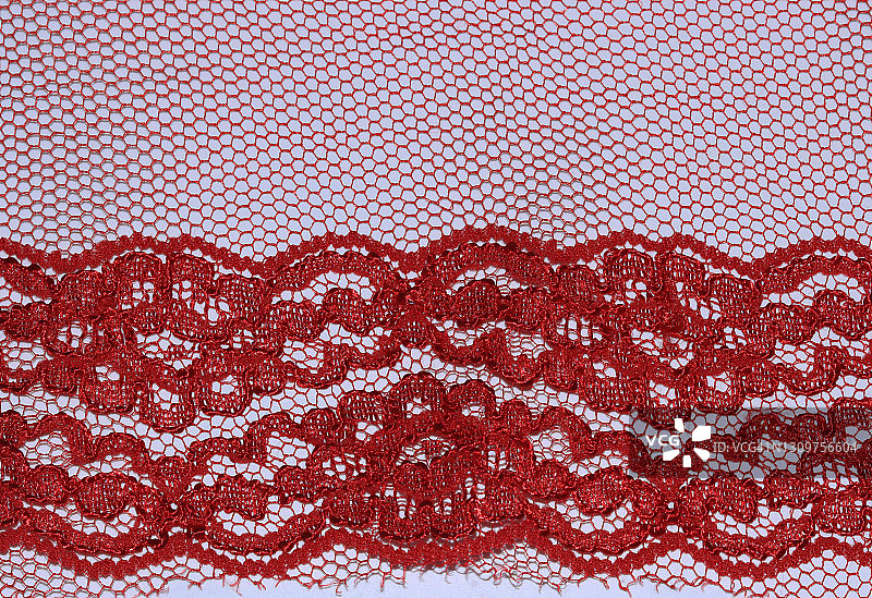 白色背景下，柔软薄纱面料上的红色蕾丝图片素材