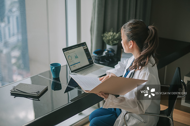 中国女医生用笔记本电脑处理医疗报告图片素材