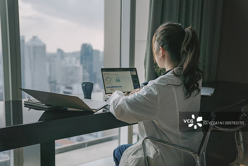 中国女医生用笔记本电脑处理医疗报告图片素材