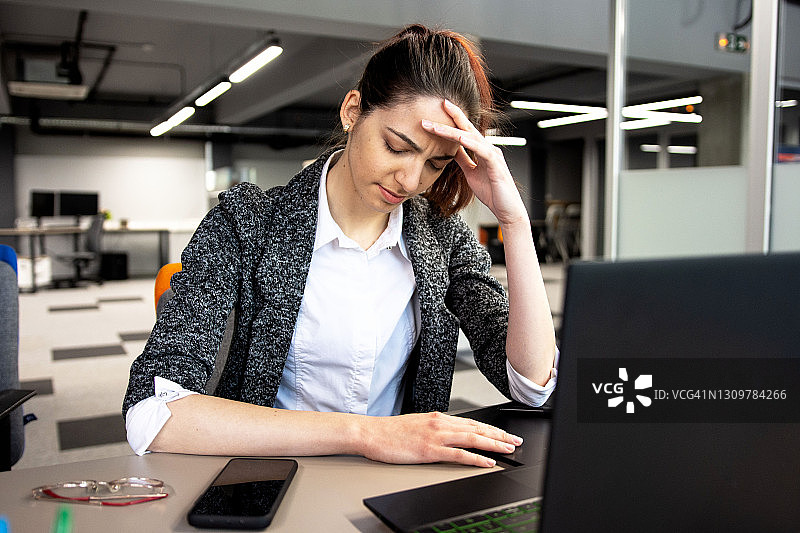 办公室里的辛勤工作：疲惫的职场女性图片素材