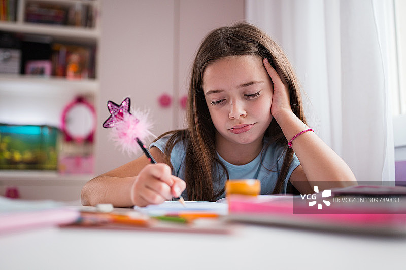 不高兴的女学生在写作业图片素材