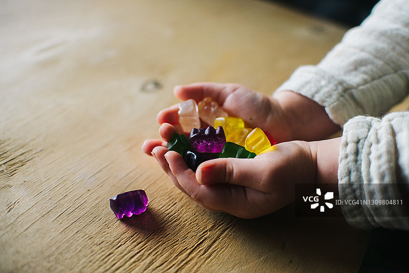 小女孩玩彩色小熊软糖图片素材