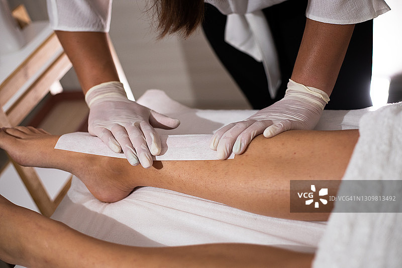 美容师为女士做腿部脱毛图片素材