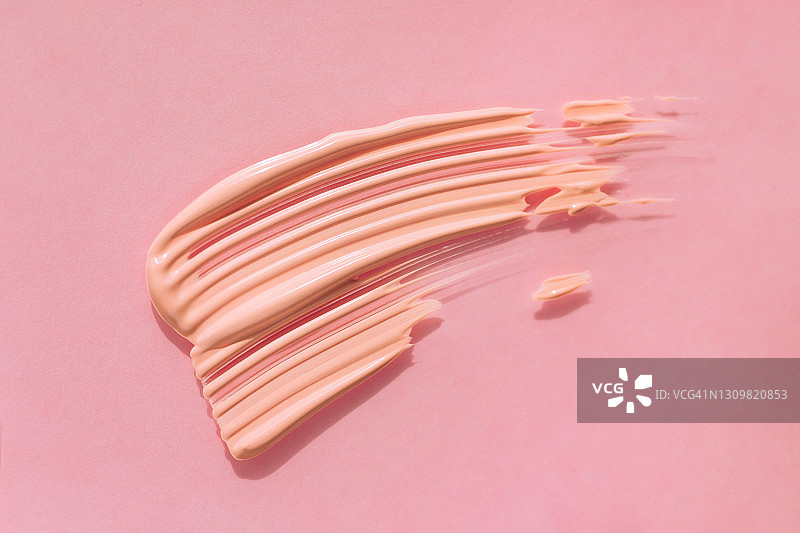 粉色背景上的粉底霜涂抹纹理图片素材