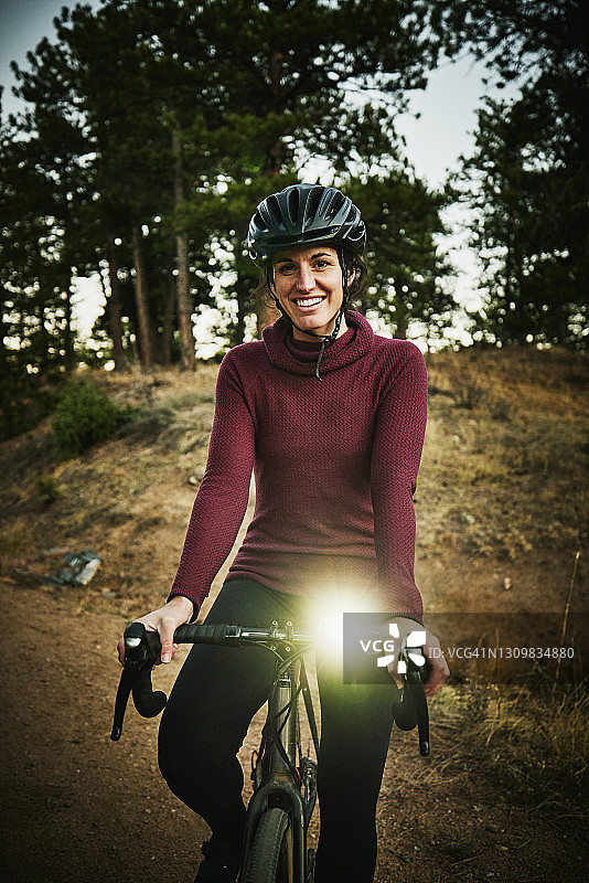 夜间森林道路骑行微笑女运动员肖像图片素材