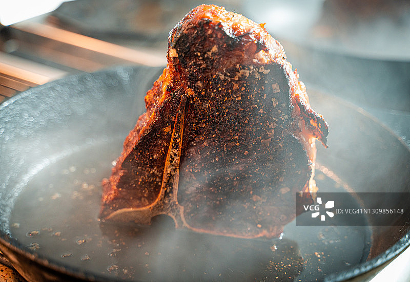 在铸铁锅上煎制T骨牛排图片素材