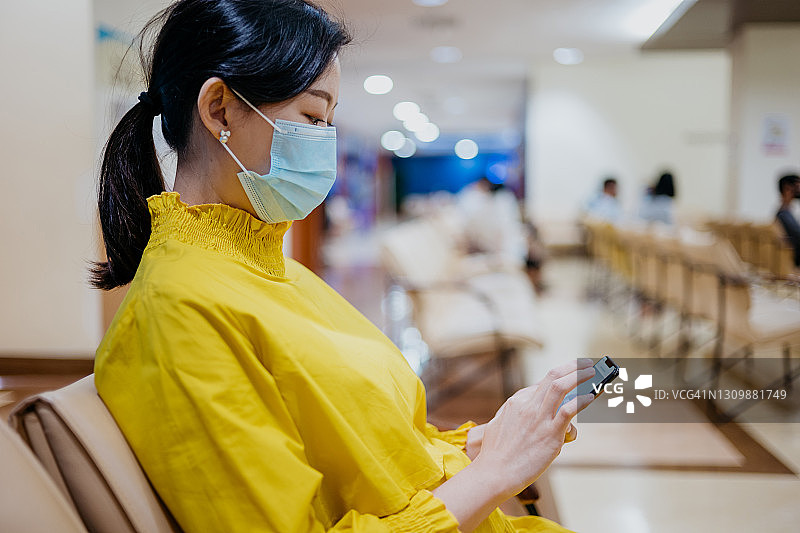在医院使用智能手机的亚洲孕妇图片素材