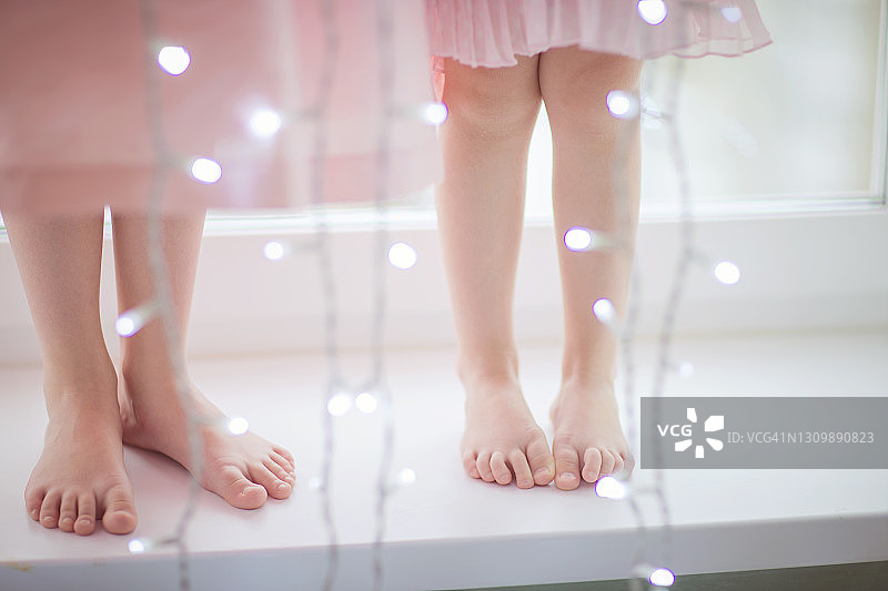 两个赤脚站在窗台上的女孩的库存照片图片素材