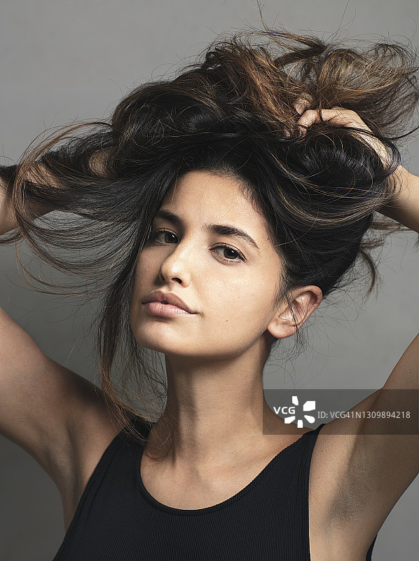 一位黑发美女正在做自己发型的肖像图片素材
