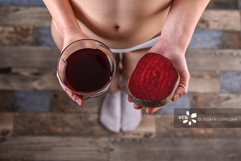 年轻女子手拿新鲜甜菜和甜菜汁图片素材