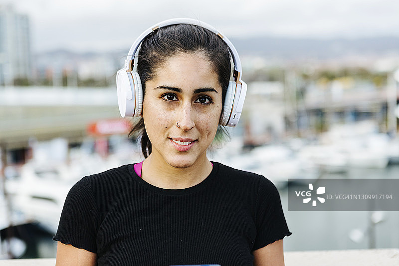 戴着耳机的年轻西班牙裔女子图片素材