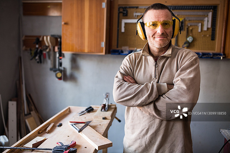 面带微笑看着镜头的快乐年长木匠图片素材