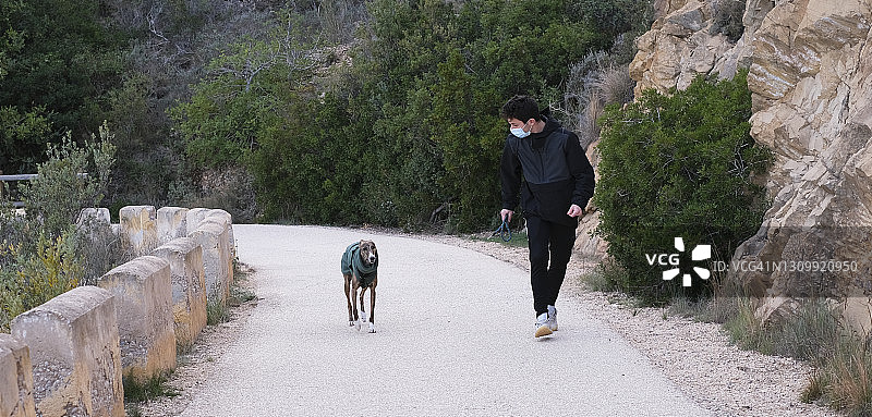 年轻男人遛狗，留白图片素材