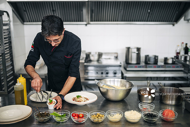 男厨师在现代厨房工作图片素材