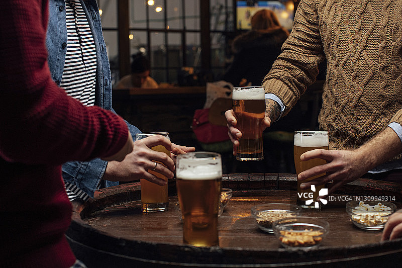 啤酒和小吃：酒吧里一群身份不明的男人，特写镜头图片素材