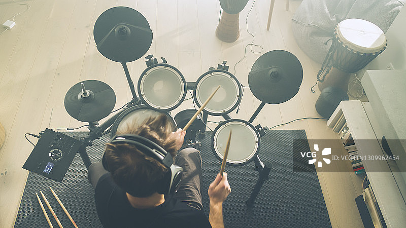 在客厅练习电子鼓的男人图片素材