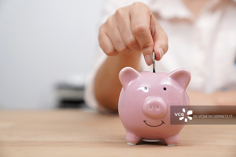 把钱存入存钱罐图片素材