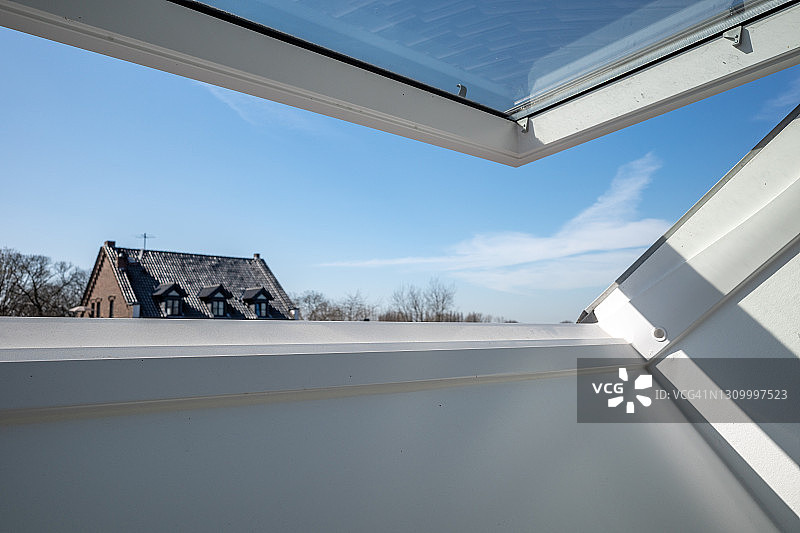 阁楼白色倾斜天窗：晴朗蓝天背景图片素材