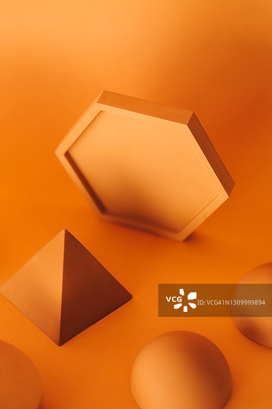 黄色背景上的抽象混凝土黄色图形：六边形、金字塔和半球图片素材