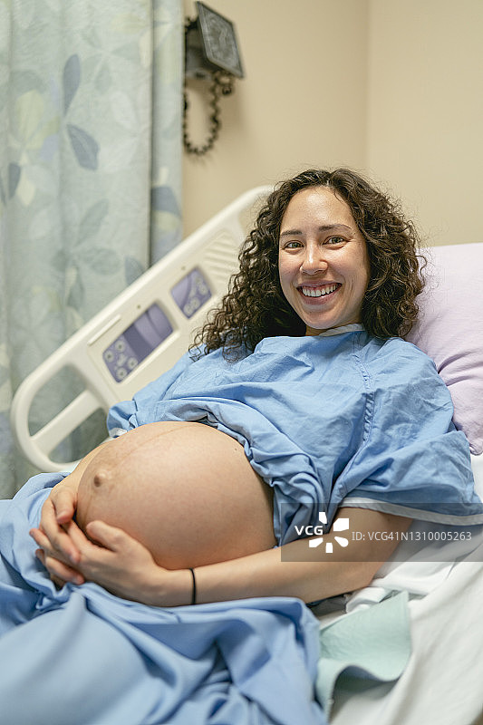 在病床上抚摸孕肚的少数民族妇女图片素材