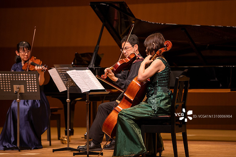 在古典音乐会上演奏小提琴、中提琴和大提琴的音乐家们图片素材