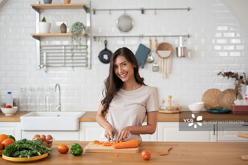 一位有魅力的年轻女性在家做饭图片素材