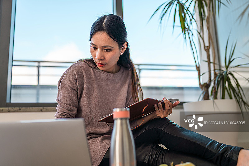 记录在线研讨会笔记的亚洲中年妇女图片素材