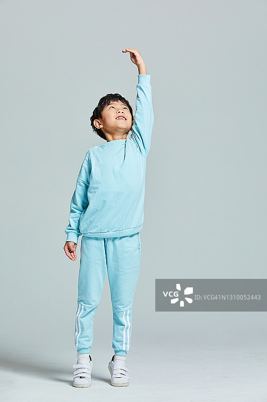 穿运动服量身高的男孩图片素材