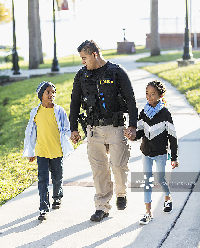社区警官与两位儿童同行图片素材