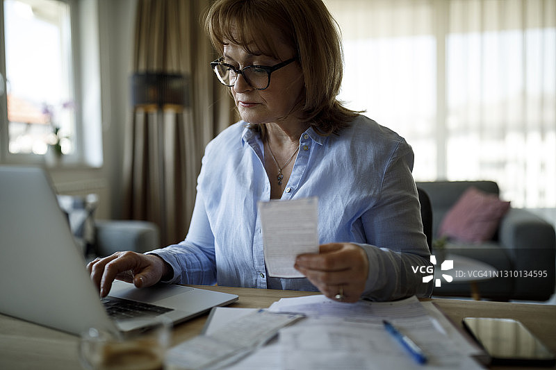 年长的女性在家支付账单图片素材