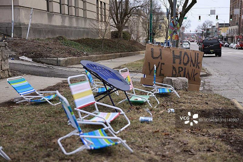 印第安纳州布卢明顿的大学生在街上举着“你按喇叭，我们喝酒”的牌子图片素材