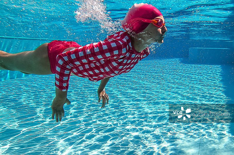 女孩在希腊的泳池中水下游泳图片素材