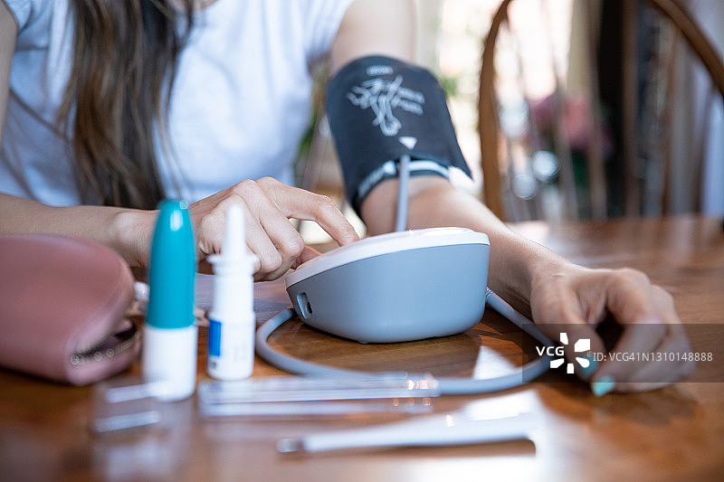女子用电子血压计自行测量血压图片素材