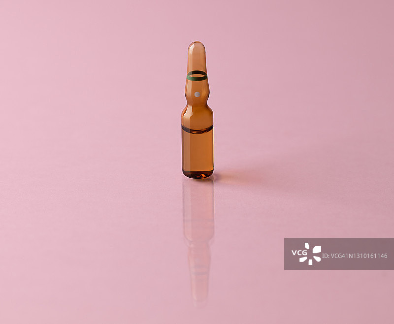 粉色反光背景下的棕色安瓿瓶图片素材