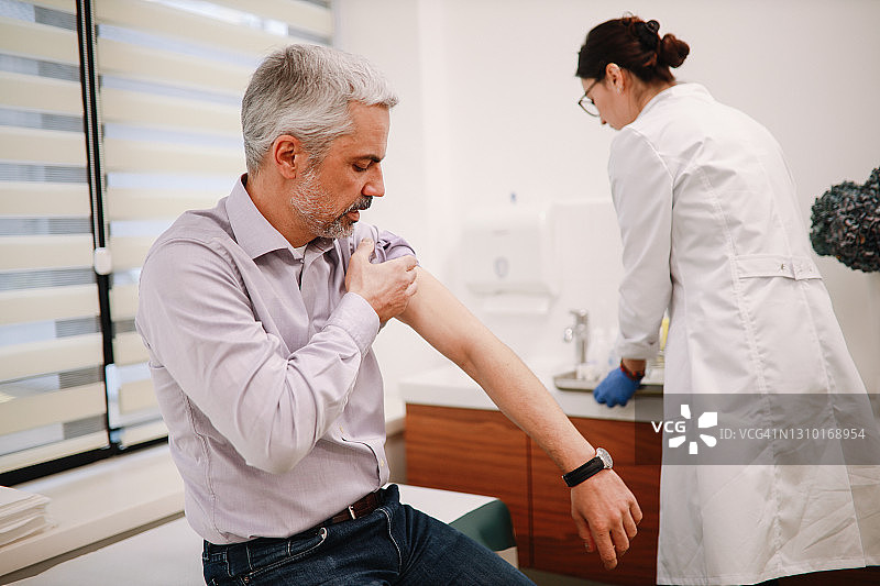 中年男子准备接种疫苗图片素材