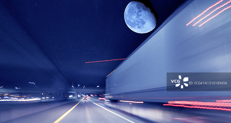 夜晚在高速公路上行驶的半挂卡车，动态模糊图片素材