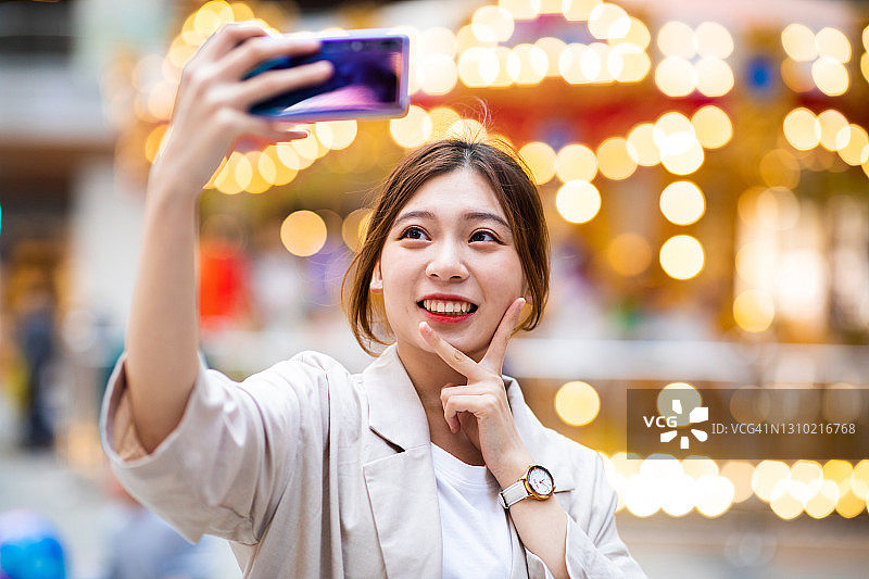 女人在夜间街道用手机自拍图片素材