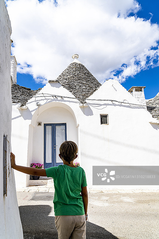 可爱的小男孩欣赏意大利阿尔贝罗贝洛的特鲁利建筑图片素材