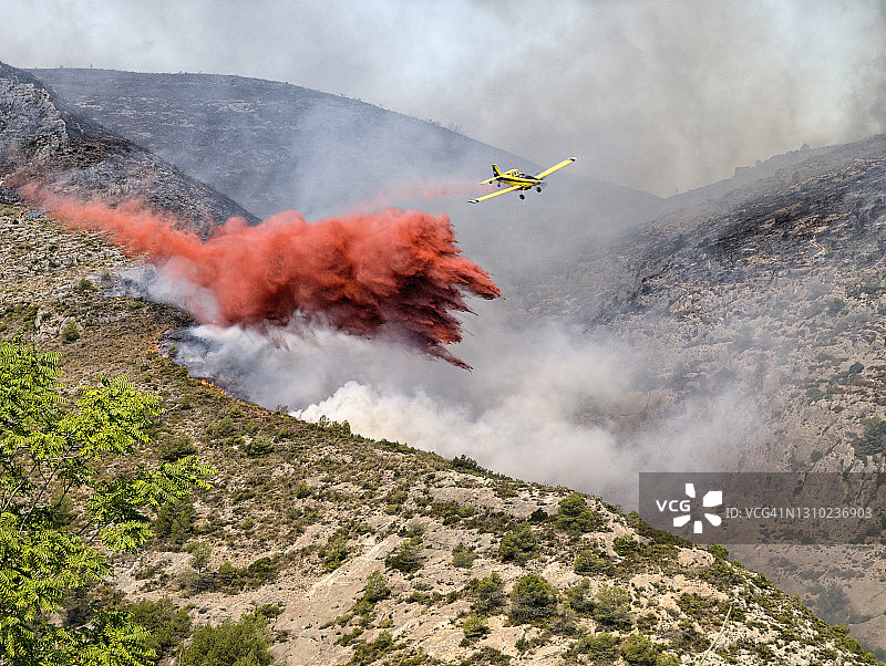 消防飞机在森林火灾中向燃烧的森林洒水图片素材