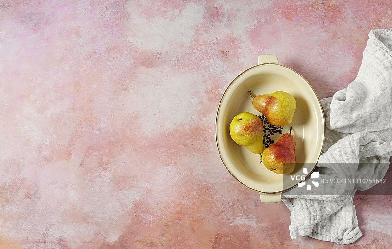 粉色背景碗里的新鲜梨图片素材