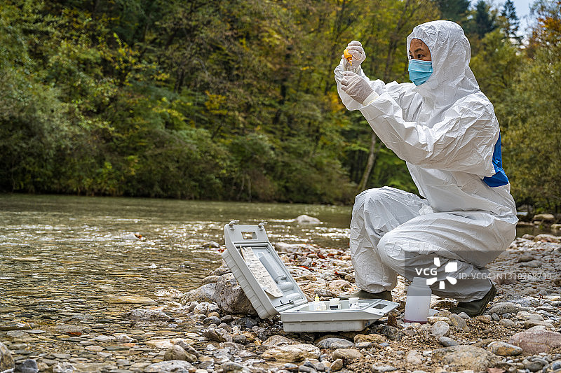 女生物学家向装有水样的试管中添加试剂图片素材
