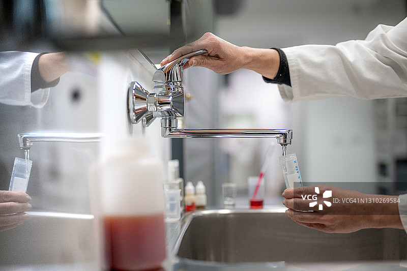 女生物学家在试管中收集自来水图片素材