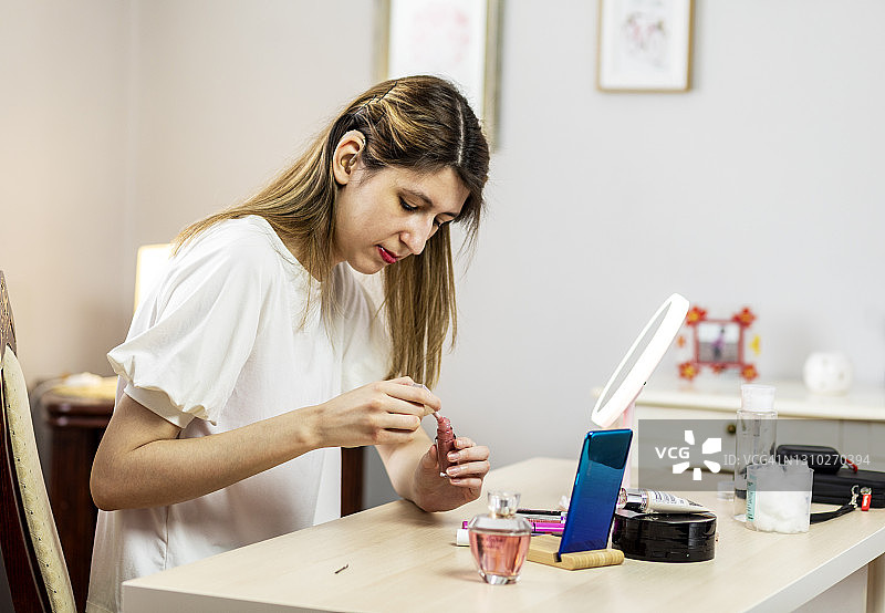 在家化妆的戴助听器年轻女人图片素材