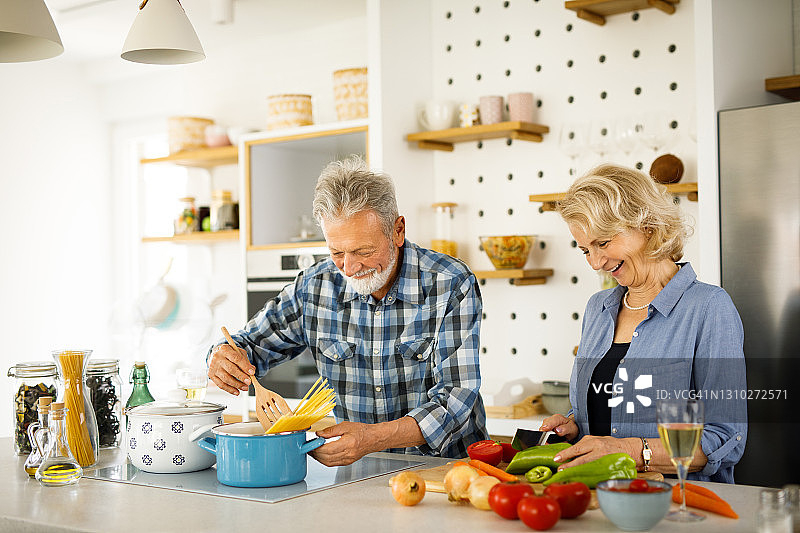 厨房里准备家庭晚餐的可爱老夫妇图片素材