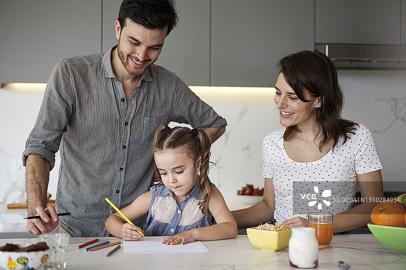 父母帮助女儿在厨房画画图片素材