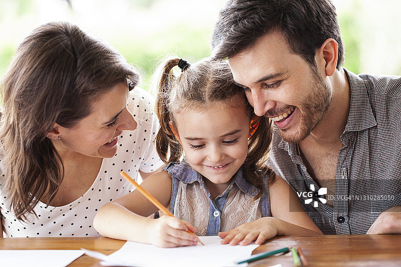 父母帮助女儿在厨房画画图片素材