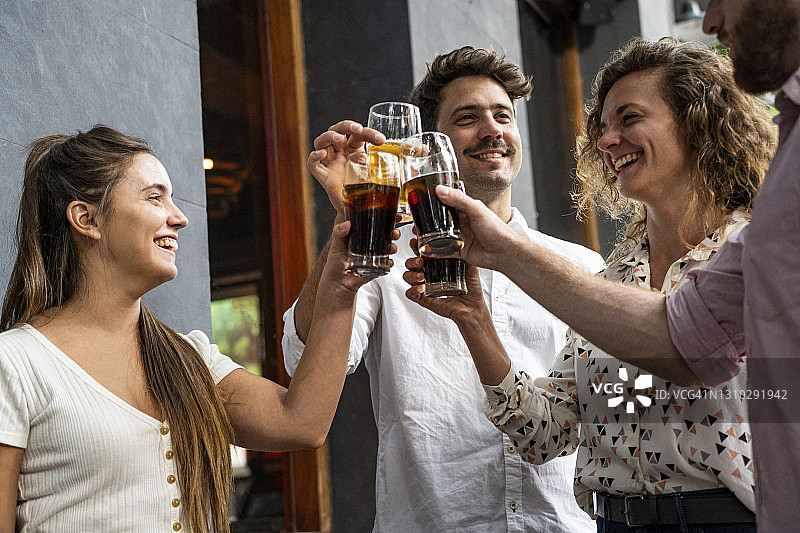 在啤酒花园里举杯畅饮的快乐年轻朋友图片素材