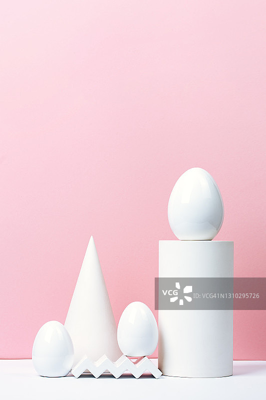 白色陶瓷复活节组合：粉色背景上的鸡蛋和各种几何形状图片素材