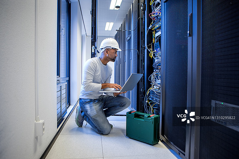 在重新开业的企业中工作的黑色男性服务器机房技术员图片素材